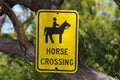 A yellow shaped Quarter horse crossing sign with a horse and rider symbol Royalty Free Stock Photo