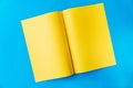 Yellow sheet of A3 paper folded in the middle in a spread on a blue background Royalty Free Stock Photo