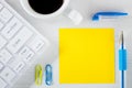 Yellow sheet of paper with space for text. Office accessories, computer keyboard, pen, coffee staples Royalty Free Stock Photo