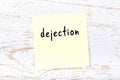 Yellow sheet of paper with word dejection. Reminder concept Royalty Free Stock Photo