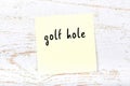 Yellow sheet of paper with word golf hole. Reminder concept