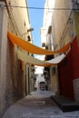 Yellow sheets positioned between two walls to provide shade