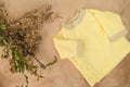Yellow shirt for infant baby and bouquet of flowers. Baby birthing concept. Expecting a child.
