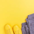 Yellow shoes with gray jeans on yellow background. Royalty Free Stock Photo