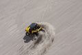 Yellow side by side buggy racing by in the sand dunes