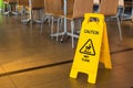 Yellow sign that alerts for wet floor in the restaurant.Thailand.