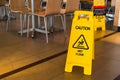 Yellow sign that alerts for wet floor in the restaurant.Thailand.