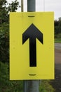 Yellow sign with Black arrow used for marathon runners Royalty Free Stock Photo