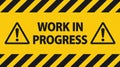 A yellow sign with black stripes and the words work in progress and two warning symbols on it Royalty Free Stock Photo