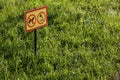 yellow sign with chemical application no dogs on green lawn background - close-up with selective focus Royalty Free Stock Photo