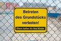 Yellow sign on fence saying: Entering the property prohibited. Parents are responsible for their children german: Betreten des Royalty Free Stock Photo