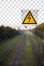 The yellow sign of high voltage over the railroad Royalty Free Stock Photo