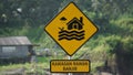 Yellow sign with a natural background. Kawasan rawan banjir means flood prone area Royalty Free Stock Photo