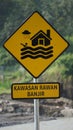 Yellow sign with a natural background. Kawasan rawan banjir means flood prone area Royalty Free Stock Photo