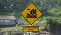 Yellow sign with a natural background. Kawasan rawan banjir means flood prone area Royalty Free Stock Photo