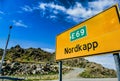 Yellow sign surrounded by mountains under a blue sky Royalty Free Stock Photo