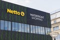 Yellow signboard of a popular food store in Denmark - Netto and Waterfront shopping. Royalty Free Stock Photo