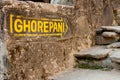 Yellow signpost arrow on the stone wall heading to Ghorepani on Poon Hill, Annapurna circuit trek, Nepal, Himalayas Royalty Free Stock Photo