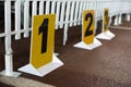 Yellow signs with numbers and white fence prepared