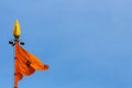 Yellow Sikh flag (Nishan Sahib) waving in the blue sky background with copy space