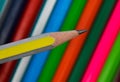 Yellow and silver striped wood pencil crayon held in front of a row of pencils Royalty Free Stock Photo