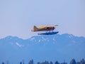 A single-engine floatplane lifting off with a view of the Olympic Mountains Royalty Free Stock Photo