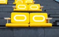 Yellow sit cushions on stairs, black outdoors in bright sunlight on rooftop of tall building. Royalty Free Stock Photo