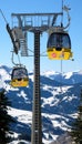 yellow ski lift cabins with snow and trees underneath the blue sunny sky above the ski slopes at wintersport mountains Royalty Free Stock Photo