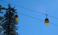 yellow ski lift cabins with snow and trees underneath the blue sunny sky above the ski slopes at wintersport mountains Royalty Free Stock Photo