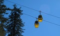 yellow ski lift cabins with snow and trees underneath the blue sunny sky above the ski slopes at wintersport mountains Royalty Free Stock Photo