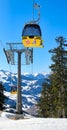 yellow ski lift cabins with snow and trees underneath the blue sunny sky above the ski slopes at wintersport mountains Royalty Free Stock Photo