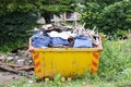 Yellow skip in countryside rural farmland for rubbish and waste