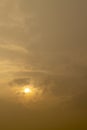 yellow sky with clouds with a white spot from the sun at sunset Royalty Free Stock Photo
