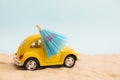 Yellow small car on beach and sand background. Vacation concept. Retro car vacation. Royalty Free Stock Photo