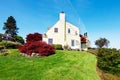 Yellow small home with water view and red maple. Royalty Free Stock Photo