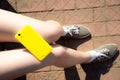 Yellow smartphone on the girl's legs