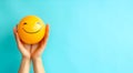 Yellow smiley ball in hands on a blue background Royalty Free Stock Photo