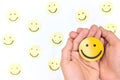 A yellow smiling face icon among a group of happy face emoticons. Positivity, attraction and happiness.