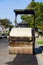 Yellow smooth drum roller parked in a residential neighborhood.