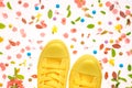 Yellow sneakers on colorful springtime decorated surface