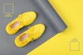 Yellow sneakers on a gray yoga mat in this year`s trendy Illuminating and Ultimate Gray colors