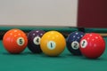 Yellow snooker ball with number one on it with other colorful balls placed in a row on a table Royalty Free Stock Photo