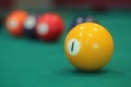 Yellow snooker ball with number one on it with other colorful balls placed in a row on a table Royalty Free Stock Photo