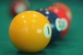 Yellow snooker ball with number one on it with other colorful balls placed in a row on a table Royalty Free Stock Photo