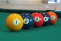 Yellow snooker ball with number one on it with other colorful balls placed in a row on a table Royalty Free Stock Photo