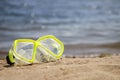 Yellow snorkelling swimming mask on the sandy seaside