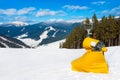 Yellow snow maker machine at ski slopes