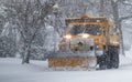 Yellow snow plow clearing roads suring peak of snow storm