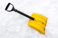 Yellow snow shovel on snow