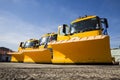 Yellow snowplow trucks in line